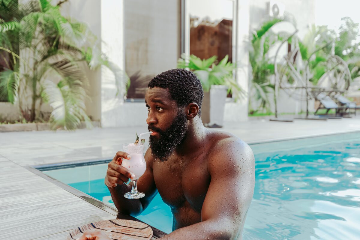 Guest relaxing with a drink by the pool